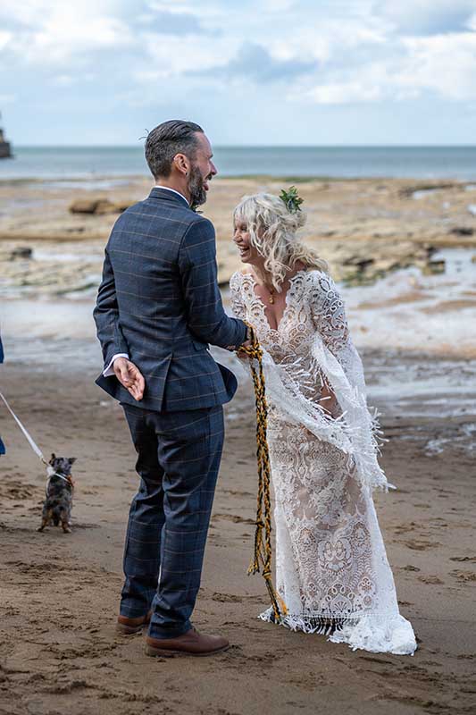 wedding couple laughing at their wedding ceremony on the beach